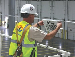 Worker installing retro reflective warehouse sign